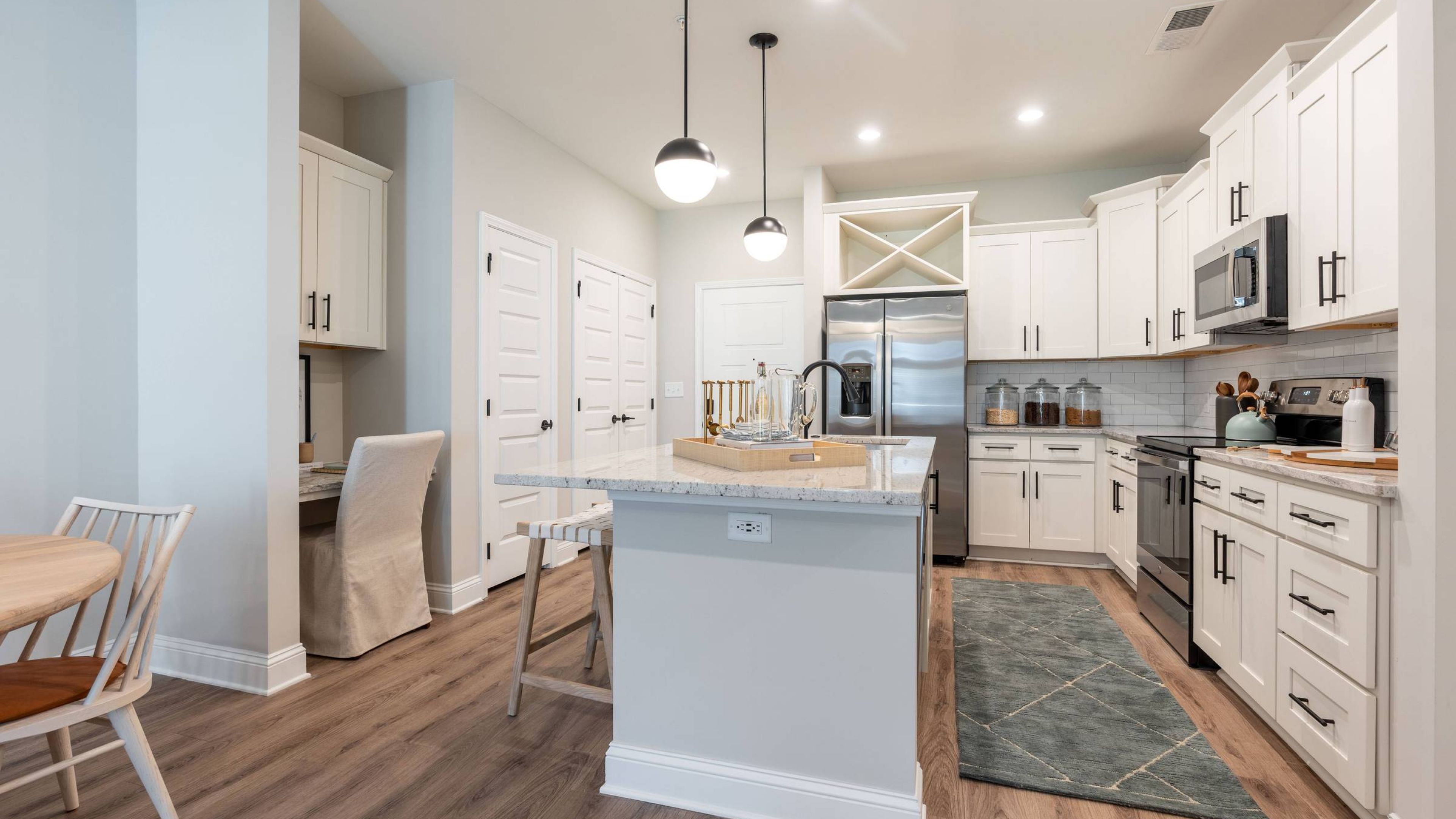 Hawthorne at Summerville apartment kitchen and living area with quartz countertops, stainless steel appliances, and ample cabinet storage